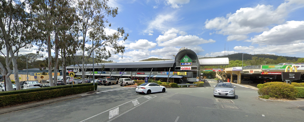 Outside The Gap Village Shopping Centre, view from the road with cars going in and out of the multilevel carpark